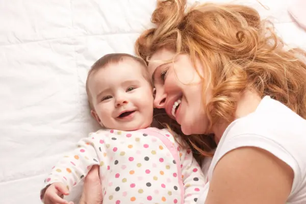 menina e mammãe deitadas sorrindo