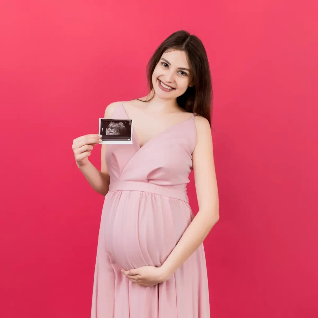 mamãe com ultrassom na mão e fundo rosa