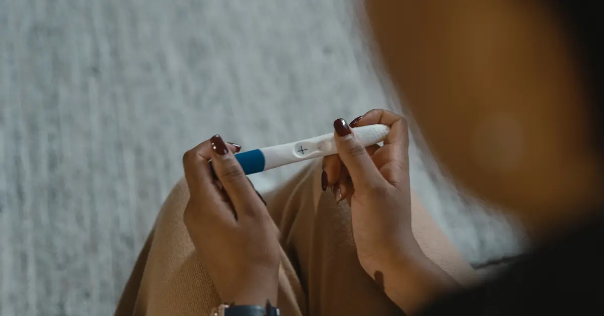 mulher segurando teste de gravidez, como descobrir gravidez