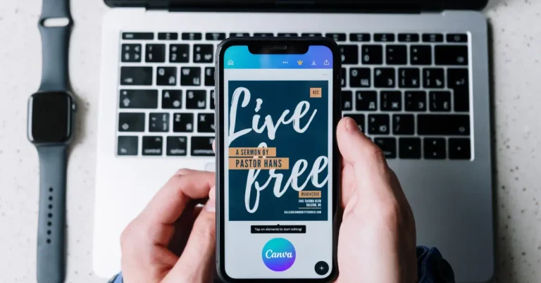 Pessoa usando o aplicativo Canva no celular para criar um produto digital passo a passo, com notebook ao fundo.